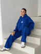 Women's blue pullover hoodie with white chest logo and hood
