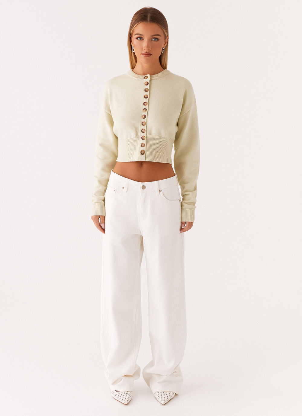 Women's cream cropped knit cardigan with brown buttons and long sleeves