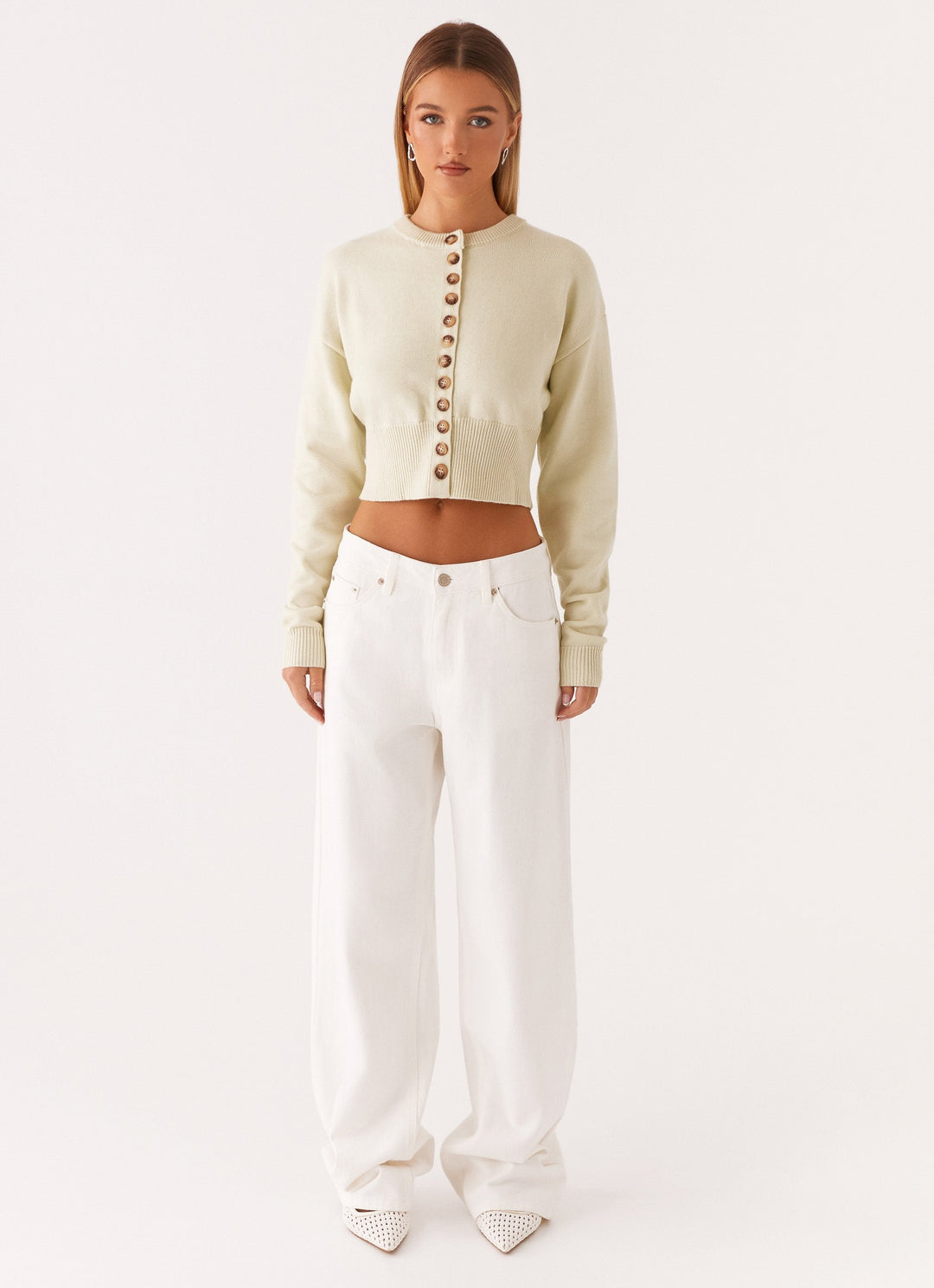 Women's cream cropped knit cardigan with brown buttons and long sleeves
