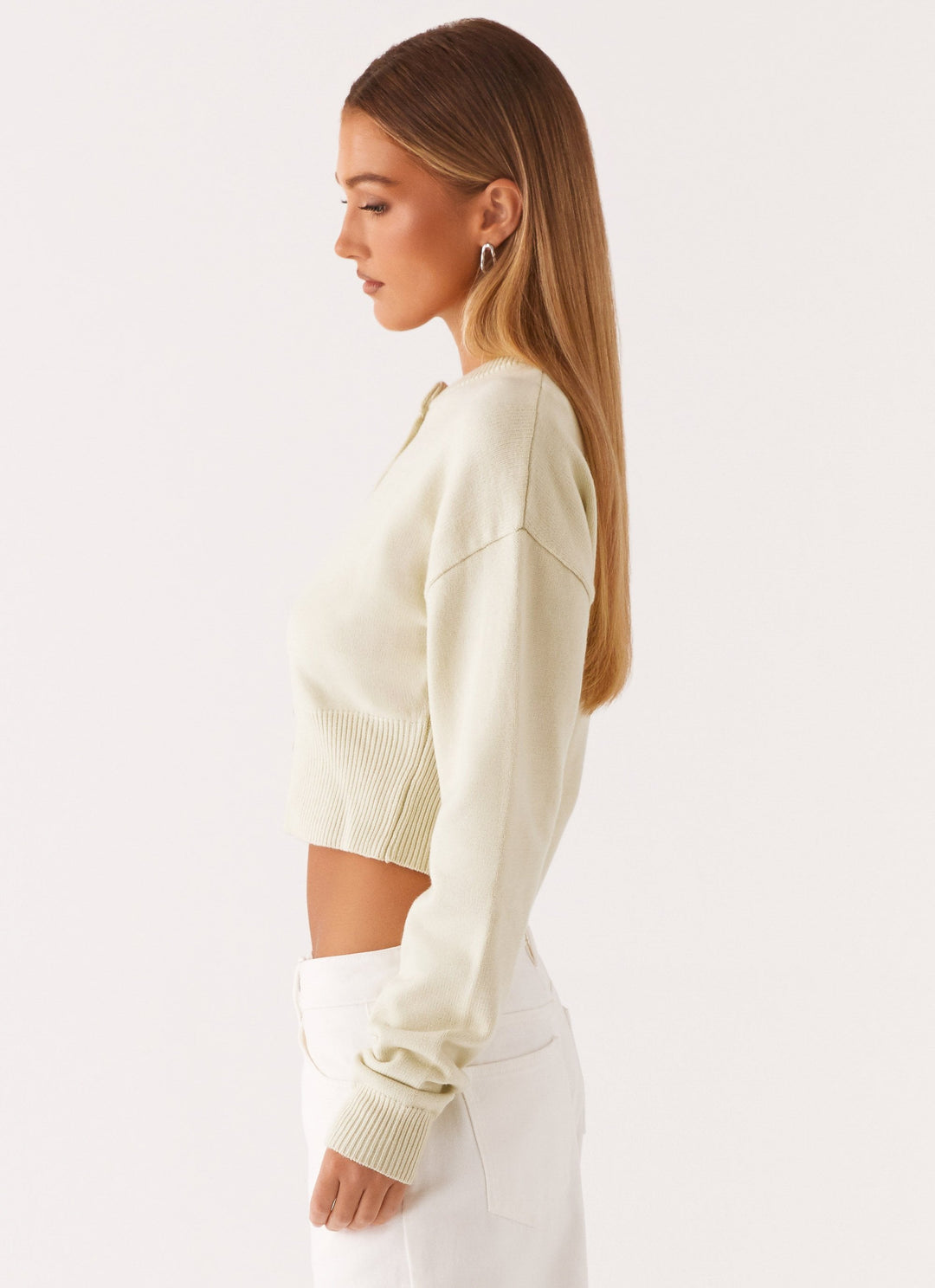 Women's cream cropped knit cardigan with brown buttons and long sleeves