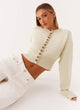 Women's cream cropped knit cardigan with brown buttons and long sleeves