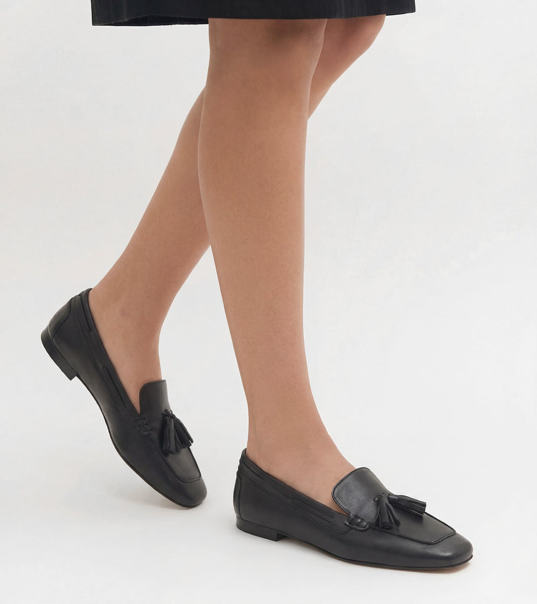 Women's black slip-on loafers with tassel trim and low heel